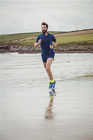 simsearch:6109-08928446,k - Handsome athlete running along the beach Photographie de stock - Premium Libres de Droits, Code: 6109-08928518