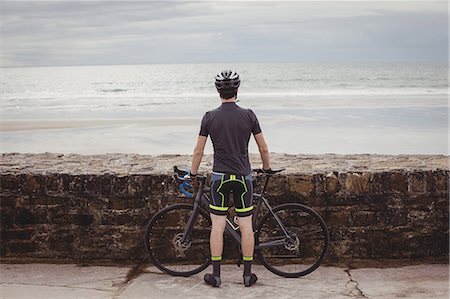 simsearch:6109-08764763,k - Rear view of athlete standing with his bicycle on the road Stock Photo - Premium Royalty-Free, Code: 6109-08928523