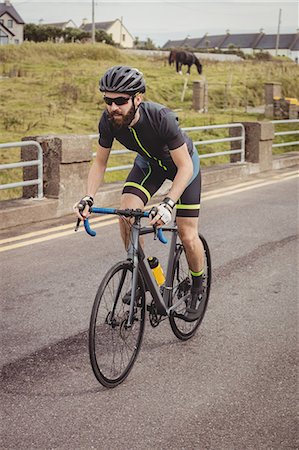 Athlete riding a bicycle on the road Stock Photo - Premium Royalty-Free, Code: 6109-08928536