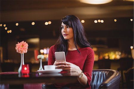 simsearch:6109-07600968,k - Woman holding mobile phone in restaurant Stock Photo - Premium Royalty-Free, Code: 6109-08928663