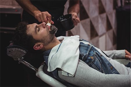 simsearch:6109-08705418,k - Mid section of barber applying cream on clients beard in baber shop Foto de stock - Sin royalties Premium, Código: 6109-08928747