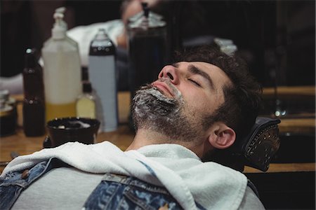 simsearch:6109-08705289,k - Man with shaving cream on beard relaxing on chair in barber shop Photographie de stock - Premium Libres de Droits, Code: 6109-08928744