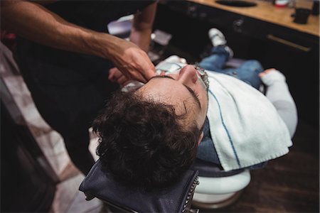 simsearch:6109-08928845,k - Man getting his beard shaved in barber shop Fotografie stock - Premium Royalty-Free, Codice: 6109-08928756