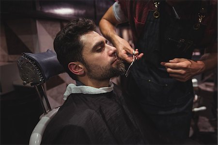 simsearch:6109-08928845,k - Man getting his beard trimmed with scissor in barber shop Fotografie stock - Premium Royalty-Free, Codice: 6109-08928763