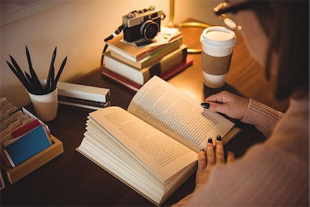 simsearch:6109-08944595,k - Woman reading book while having coffee in living room at home Photographie de stock - Premium Libres de Droits, Code: 6109-08928725