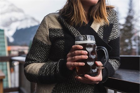 Mid section of woman in winter clothing holding beer glass in bar Stock Photo - Premium Royalty-Free, Code: 6109-08928856