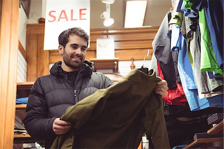 ropa de invierno - Man selecting apparel in a clothes shop Foto de stock - Sin royalties Premium, Código: 6109-08928898