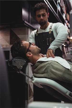 simsearch:6109-08928831,k - Barber putting towel over clients neck in barber shop Stockbilder - Premium RF Lizenzfrei, Bildnummer: 6109-08928838
