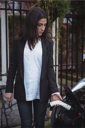 Beautiful woman charging electric car at vehicle charging station Stock Photo - Premium Royalty-Free, Code: 6109-08929053