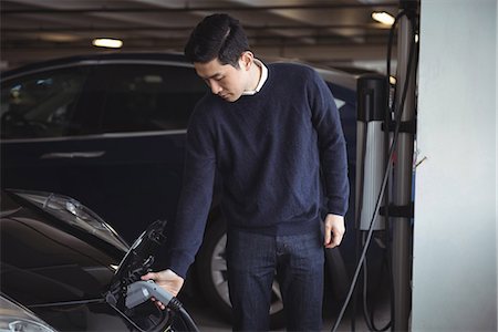 simsearch:6109-08928992,k - Handsome man charging car at electric vehicle charging station Stock Photo - Premium Royalty-Free, Code: 6109-08929095