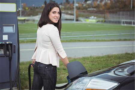simsearch:6109-08929052,k - Portrait of beautiful woman charging electric car on street Stock Photo - Premium Royalty-Free, Code: 6109-08929024