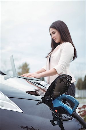 simsearch:6109-08929014,k - Beautiful woman using laptop while charging electric car on street Stock Photo - Premium Royalty-Free, Code: 6109-08929029