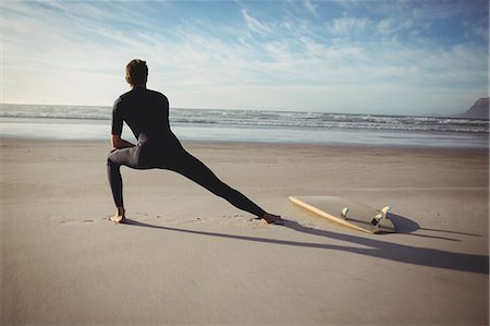 simsearch:6109-08929136,k - Rear view of man with surfboard exercising on beach Stockbilder - Premium RF Lizenzfrei, Bildnummer: 6109-08929141