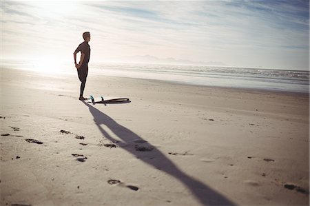 simsearch:6109-08929136,k - Rear view of man with surfboard exercising on beach Stockbilder - Premium RF Lizenzfrei, Bildnummer: 6109-08929144