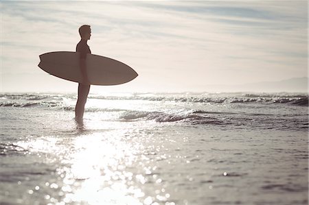 simsearch:649-07437735,k - Silhouette of thoughtful surfer standing with surfboard on beach Photographie de stock - Premium Libres de Droits, Code: 6109-08929152