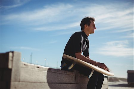 simsearch:6109-08929136,k - Thoughtful surfer sitting on a wooden platform with surfboard on beach Stockbilder - Premium RF Lizenzfrei, Bildnummer: 6109-08929161