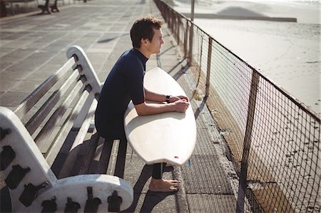 simsearch:6109-08929136,k - Thoughtful surfer sitting with surfboard on pier at beach Stockbilder - Premium RF Lizenzfrei, Bildnummer: 6109-08929169