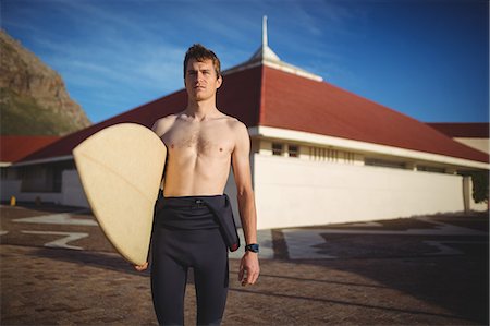 simsearch:649-07437735,k - Thoughtful surfer standing with surfboard on beach Photographie de stock - Premium Libres de Droits, Code: 6109-08929120