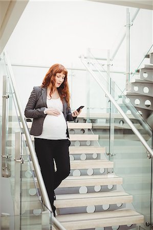 simsearch:6102-08996340,k - Pregnant businesswoman walking down stairs in office Stockbilder - Premium RF Lizenzfrei, Bildnummer: 6109-08929342