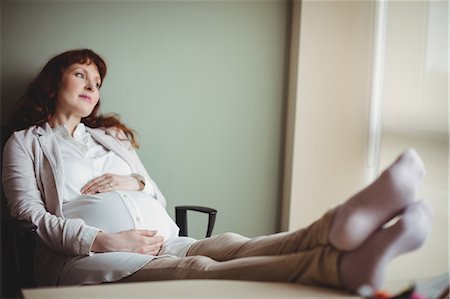 expectation - Pregnant businesswoman relaxing with her feet up in office Stock Photo - Premium Royalty-Free, Code: 6109-08929328