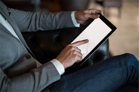 simsearch:6109-08929459,k - Mid section of businessman using digital tablet in waiting area at airport terminal Foto de stock - Royalty Free Premium, Número: 6109-08929459