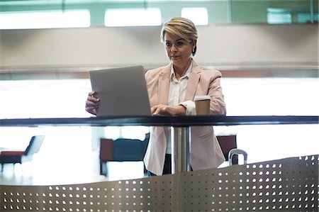 simsearch:400-04520739,k - Businesswoman using laptop in waiting area at airport terminal Foto de stock - Sin royalties Premium, Código: 6109-08929466