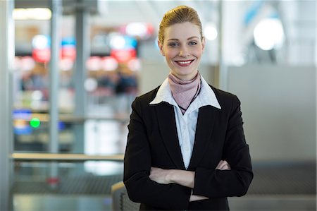 simsearch:6109-08929425,k - Portrait of smiling airline check-in attendant at counter in airport terminal Foto de stock - Sin royalties Premium, Código: 6109-08929408