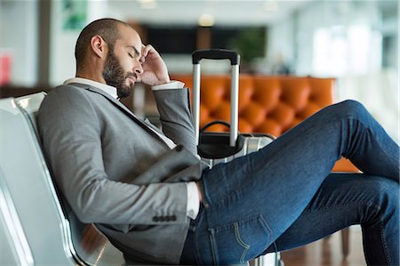 simsearch:6109-08929459,k - Businessman sleeping on chair in waiting area at the airport terminal Foto de stock - Royalty Free Premium, Número: 6109-08929437
