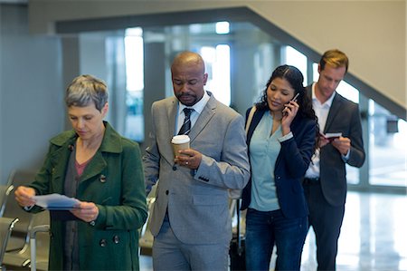 simsearch:6109-08802775,k - Business commuters waiting in queue at airport Photographie de stock - Premium Libres de Droits, Code: 6109-08929548