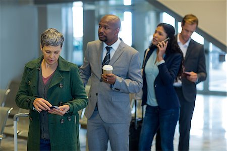 simsearch:6109-08722553,k - Business commuters waiting in queue at airport Foto de stock - Royalty Free Premium, Número: 6109-08929549