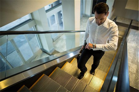 simsearch:632-03847867,k - Commuter looking time while walking on escalator in airport Stock Photo - Premium Royalty-Free, Code: 6109-08929562