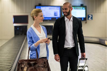 simsearch:6109-08802812,k - Smiling couple walking with their trolley bags in airport terminal Stockbilder - Premium RF Lizenzfrei, Bildnummer: 6109-08929515