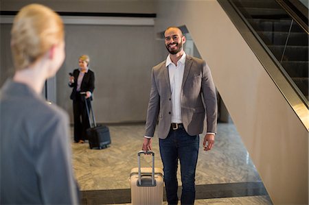 simsearch:6113-07731695,k - Businesspeople walking with luggage at airport terminal Stockbilder - Premium RF Lizenzfrei, Bildnummer: 6109-08929601