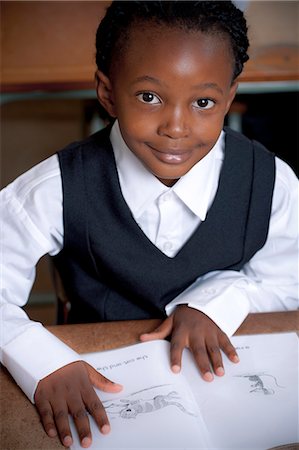 simsearch:6110-06702680,k - Young African student working in a classroom and smiling at camera Foto de stock - Sin royalties Premium, Código: 6110-06702593