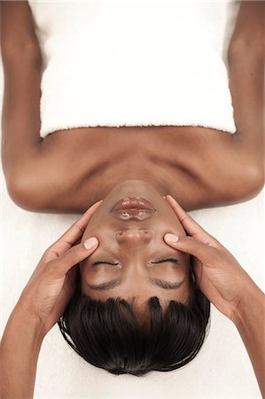 simsearch:6110-06702760,k - Young black woman in a salon receiving a facial massage Fotografie stock - Premium Royalty-Free, Codice: 6110-06702698