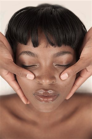 simsearch:6110-06702760,k - Young black woman in a salon receiving a facial massage Fotografie stock - Premium Royalty-Free, Codice: 6110-06702699