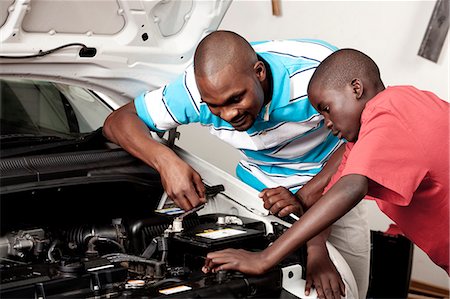 simsearch:6110-06702795,k - African father and son work on a car engine together Foto de stock - Royalty Free Premium, Número: 6110-06702623