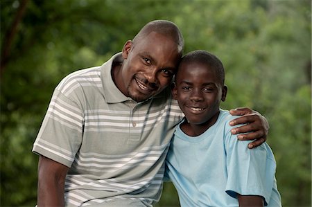 simsearch:6110-06702795,k - African father and son sitting outside in a garden Foto de stock - Royalty Free Premium, Número: 6110-06702626