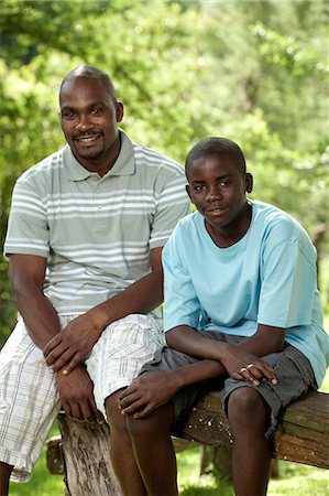 simsearch:6110-06702795,k - African father and son sitting outside in a garden Foto de stock - Royalty Free Premium, Número: 6110-06702628