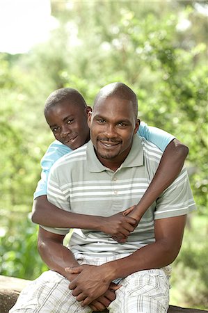 simsearch:6110-06702795,k - African father and son sitting outside in a garden Foto de stock - Royalty Free Premium, Número: 6110-06702633