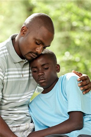 simsearch:6110-06702795,k - African father and son sitting outside in a garden Foto de stock - Royalty Free Premium, Número: 6110-06702632