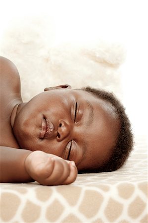 simsearch:6110-06702748,k - An infant sleeping on a blanket, headshot Foto de stock - Royalty Free Premium, Número: 6110-06702753