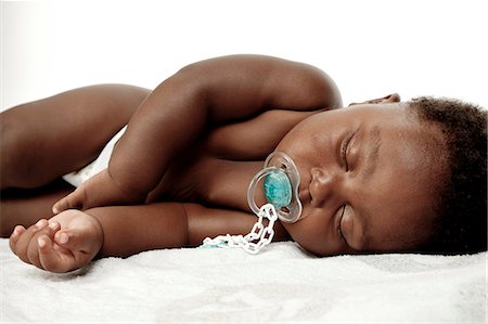 An infant sleeping with a dummy in his mouth Photographie de stock - Premium Libres de Droits, Code: 6110-06702750