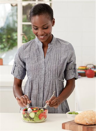 simsearch:6110-06702795,k - Young African mother making food in the kitchen Foto de stock - Royalty Free Premium, Número: 6110-06702769