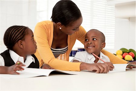 simsearch:6110-06702656,k - Young African mother helping her children with their homework Foto de stock - Royalty Free Premium, Número: 6110-06702793