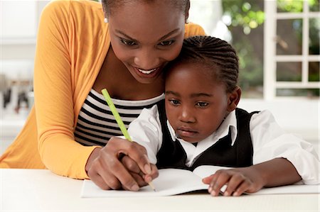 simsearch:6110-06702656,k - Young African mother helping her daughter with her homework Foto de stock - Royalty Free Premium, Número: 6110-06702790