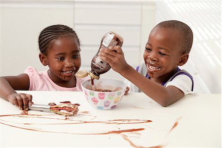 Two you African siblings make pudding together in the kitchen Stock Photo - Premium Royalty-Free, Code: 6110-06702795