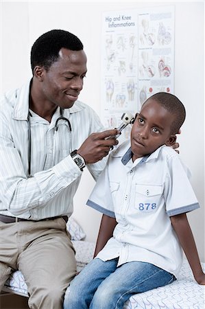 simsearch:6110-06702795,k - Doctor examining male African child in a doctor's room Foto de stock - Royalty Free Premium, Número: 6110-06702728