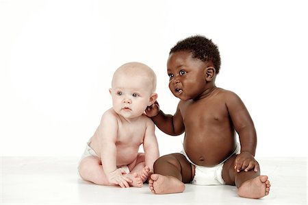 simsearch:6110-06702748,k - Two infants sitting in front of a white background Foto de stock - Royalty Free Premium, Número: 6110-06702737