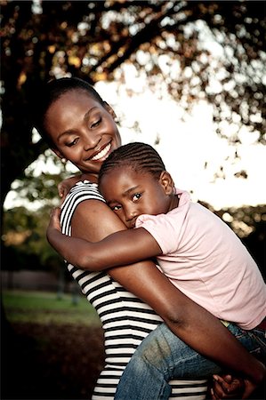 simsearch:6110-06702748,k - Young African mother holding her daughter in a park Foto de stock - Royalty Free Premium, Número: 6110-06702804